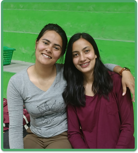Two smiling students in an agricultural setting